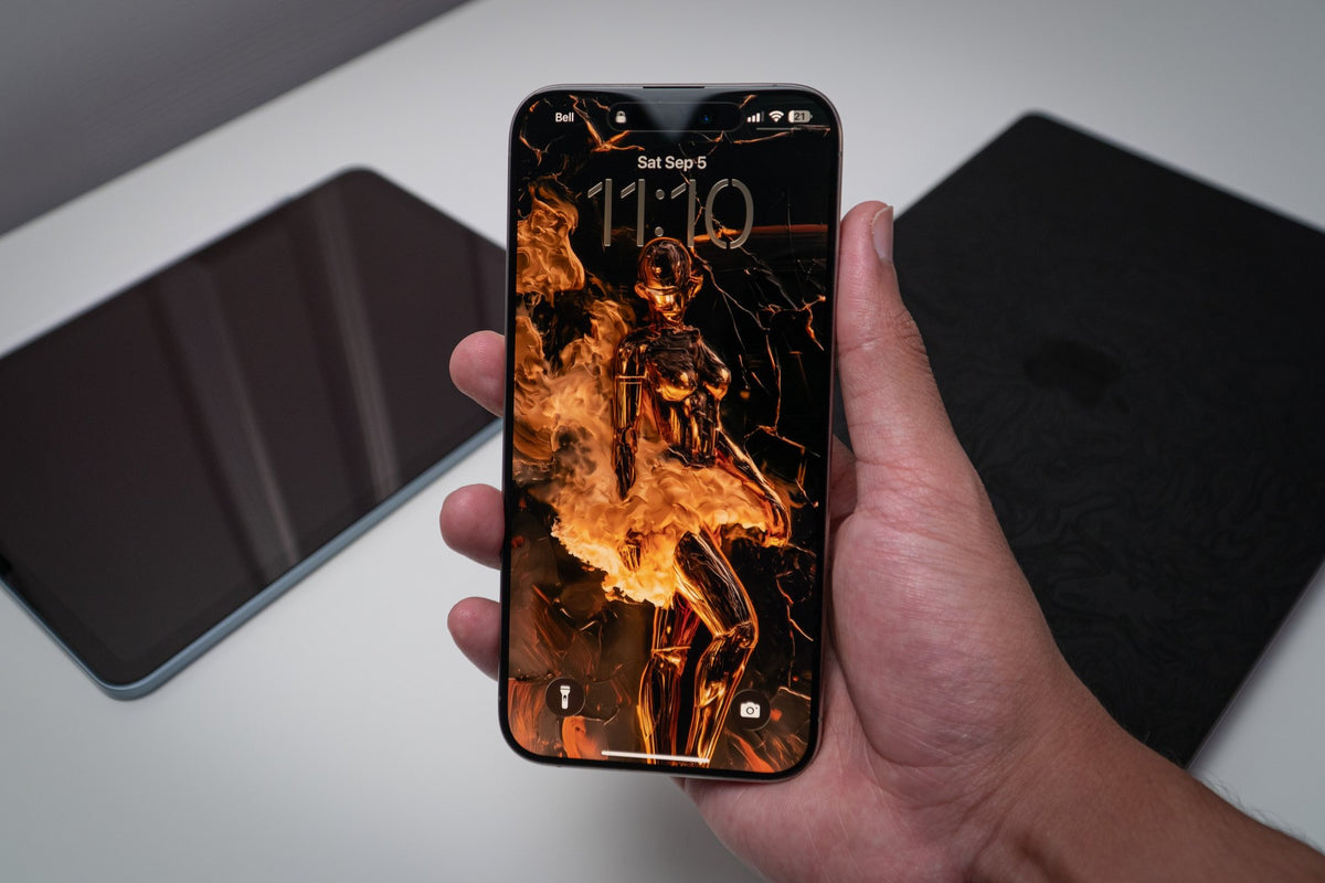 Molten-gold figure in flame, wallpaper on an iPhone lock screen, held in hand