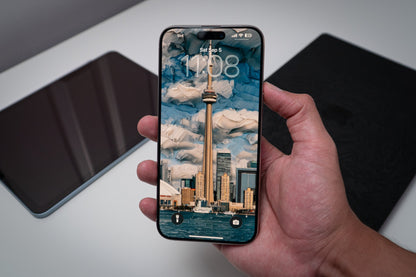 CN Tower daytime skyline wallpaper on an iPhone lock screen, held in hand