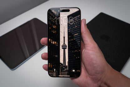 CN Tower framed by downtown towers at night, wallpaper on an iPhone lock screen