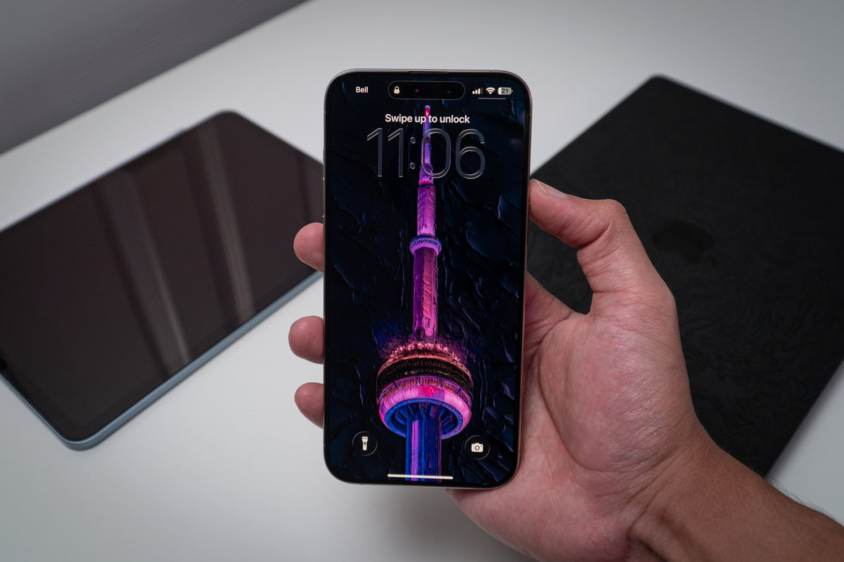 CN Tower in magenta and cyan neon, wallpaper on an iPhone lock screen