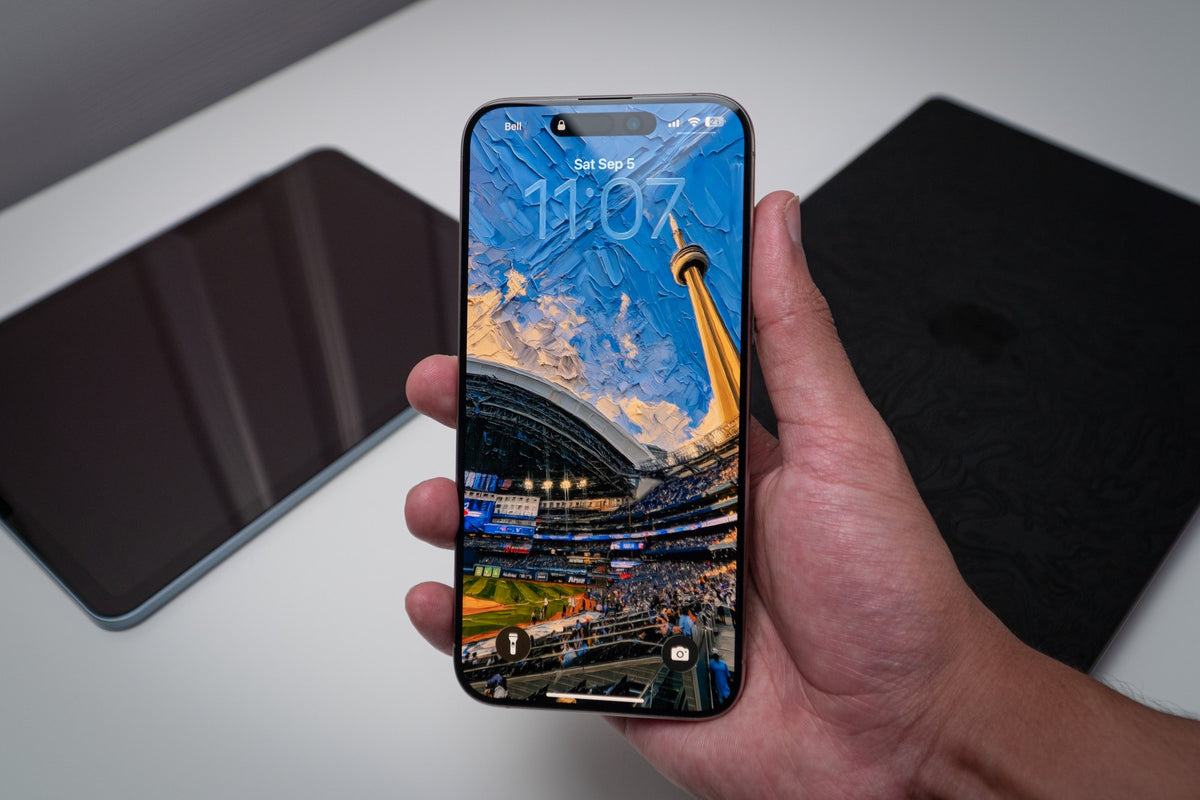 CN Tower stadium wallpaper on an iPhone lock screen, held in hand